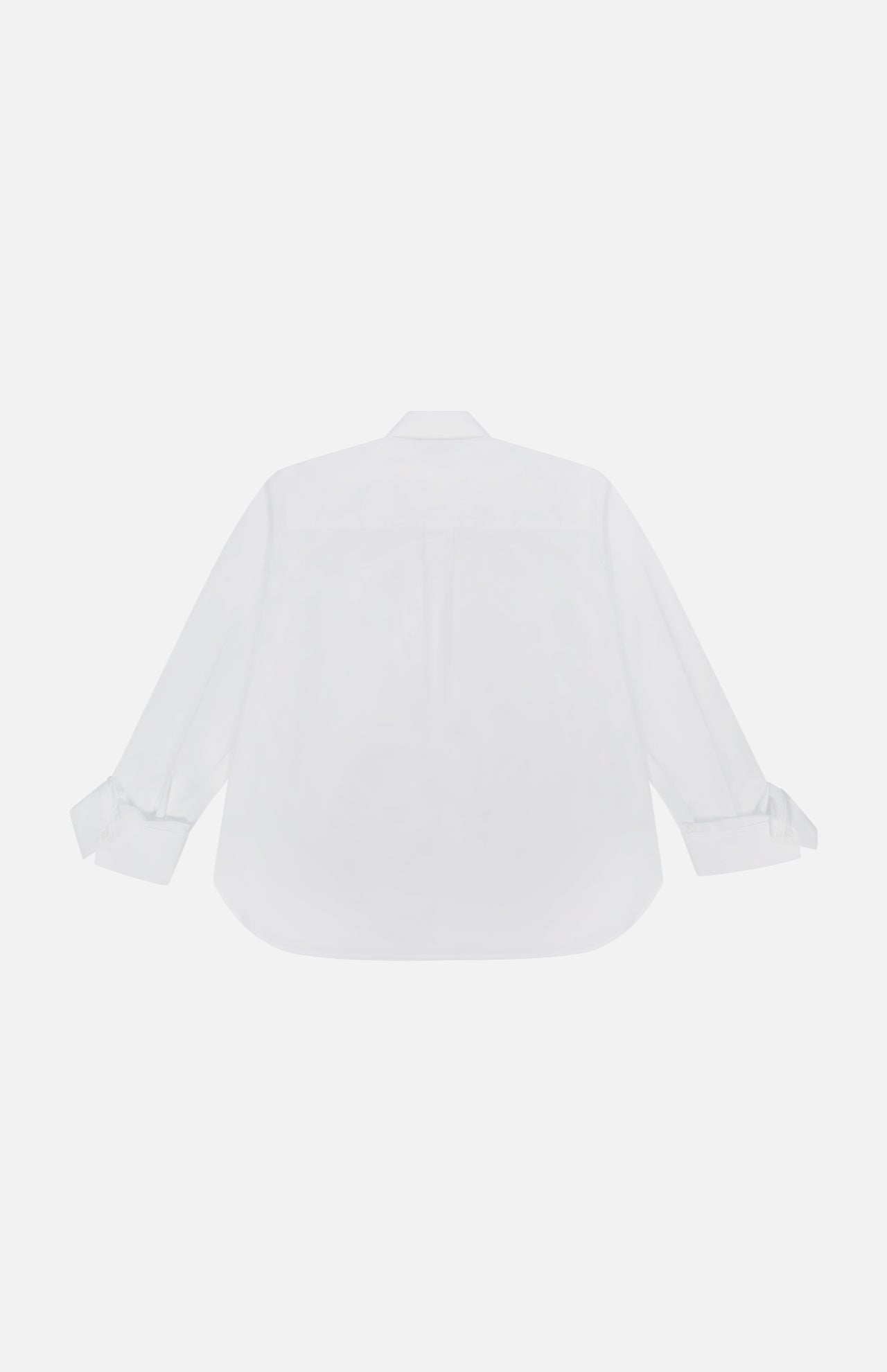 The TWP Next Morning Oversized Shirt, crafted from premium Italian cotton, is shown from the back with a classic collar and tied cuffs. This office-chic piece is laid flat on a white background.