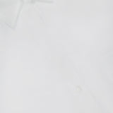 A close-up of the TWP Next Morning Oversized Shirt, crafted from Italian cotton with a pointed collar and visible buttons, featuring part of the label—an office chic staple.