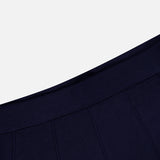 Close-up of a navy blue fabric with vertical seam lines and a ribbed waistband, set against a plain white background—perfect for highlighting the refined details of the TWP Seamed Maxi Skirt.