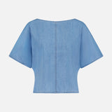 The Simple T Top by TWP is a light blue, lightweight denim tee with a relaxed fit, wide sleeves, and visible center and edge stitching. Shown from the back against a plain white background.