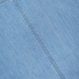 Close-up of the Simple T Top by TWP in lightweight denim, featuring a diagonal seam and a partially visible white label with black text—a modern take on women’s workwear style.