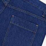 Close-up of the back pocket and stitching on TWP’s Song Sung Blue Jean in Dark Stone, highlighting the fabric texture, seams, and pocket shape against a white background.