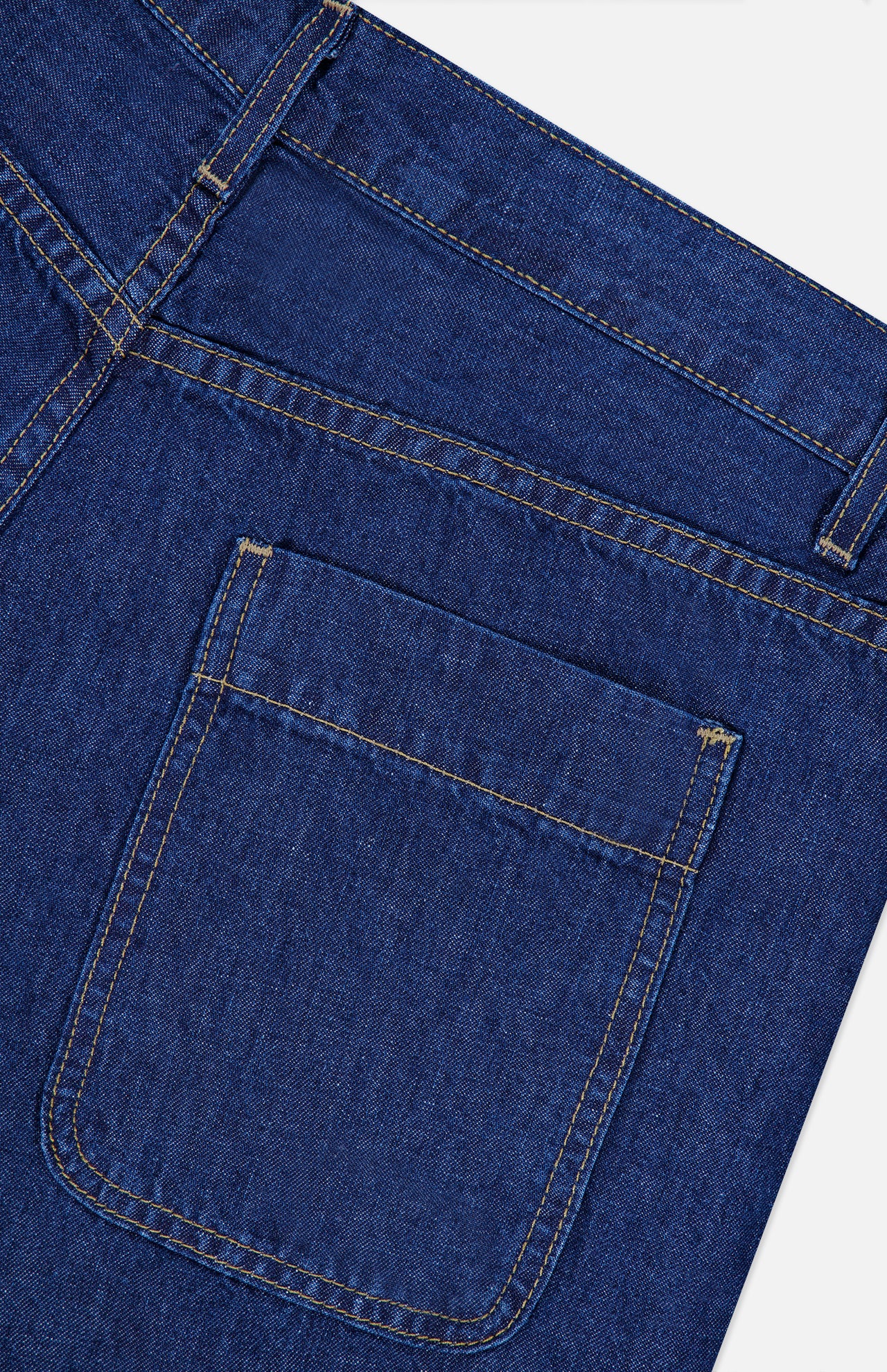 Close-up of the back pocket and stitching on TWP’s Song Sung Blue Jean in Dark Stone, highlighting the fabric texture, seams, and pocket shape against a white background.