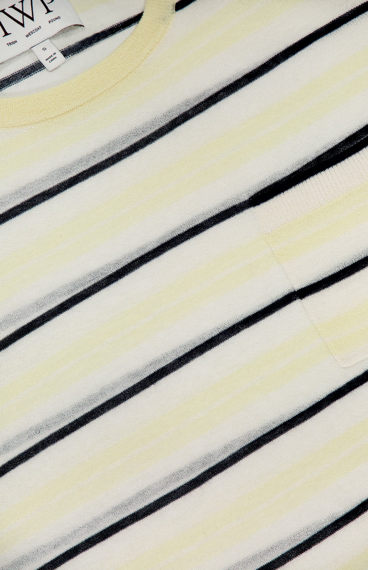 Close-up of the TWP Striped Short Sleeve T-shirt for women in light yellow and white stripes with thin black lines, a chest pocket, and a neck tag—ideal for a chic striped workwear look.