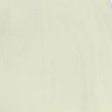 A close-up of the TWP A-Line Linen Skirt displays its light yellow, smooth linen fabric with subtle creases and no visible patterns.