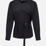 The Last Chapter Shirt by TWP features a black belted design with long sleeves, a high neck, asymmetrical front closure, and distinctive button accents at the shoulder and cuffs. Expertly crafted from Italian wool twill for sophisticated women’s workwear, it is shown against a plain white background.