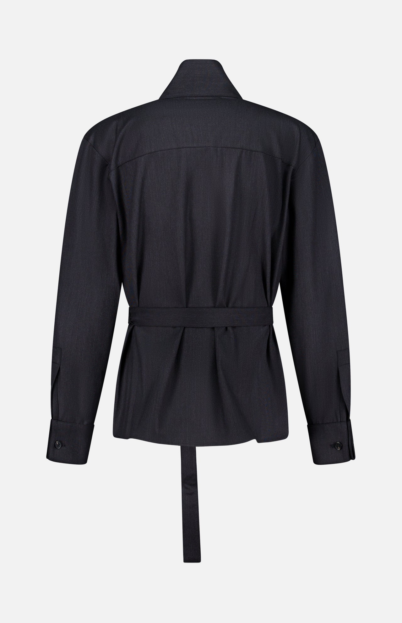 The Last Chapter Shirt by TWP is showcased from the back in black, featuring a long-sleeve belted silhouette with a collar, buttoned cuffs, and a straight hem. Expertly crafted from Italian wool twill, the fabric reveals a subtle texture that fuses classic women’s workwear with sophisticated tailoring. The shirt is presented against a plain white background.