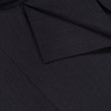 Close-up of The Last Chapter Shirt by TWP, meticulously tailored from dark Italian wool twill, featuring a folded flap and three black buttons—showcasing its rich texture and refined details that elevate classic women’s workwear.