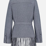 The TWP Thea Fringed Hem Cardigan is a gray long-sleeve cardigan featuring a belted waist and dramatic long fringe along the bottom hem, shown from the back against a plain white background. Button details at the cuffs add an elegant touch, making it an ideal addition to any women’s workwear wardrobe. Inspired by classic Italian cashmere styling, this design offers a modern update to the traditional grey cashmere cardigan.