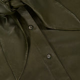 Close-up of the Tied Up In You Shirt by TWP in olive green satin, featuring an oversized neck tie and front button closure. The TWP brand label is visible at the neckline.