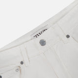 Close-up of the waistband and front pocket of the TWP West 11th St Pant in white linen-cotton denim, showing silver rivets, a button, and the brand’s label inside.