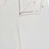 Close-up of the TWP West 11th St Pant in white linen-cotton denim, featuring a detailed waistband, unique pocket design, a partially undone front zipper, and unfastened top button—modern workwear style for women.