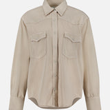 The TWP Yellowstone Western Blouse is a beige, long-sleeve button-up shirt featuring a classic collar, two chest flap pockets, and buttoned cuffs, displayed on a plain white background.