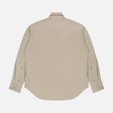 The Yellowstone Western Blouse by TWP is displayed from the back, featuring a beige color, long sleeves with buttoned cuffs, a pointed yoke detail, and is laid flat on a white background.