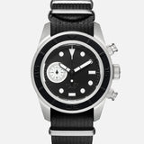 The U3-AE Unimatic Watch by UNIMATIC is an Italian-made timepiece featuring a black and silver round face, white hour markers, a small subdial, two side buttons, and a black fabric strap—showcasing classic design elements inspired by the renowned Unimatic diving watch.