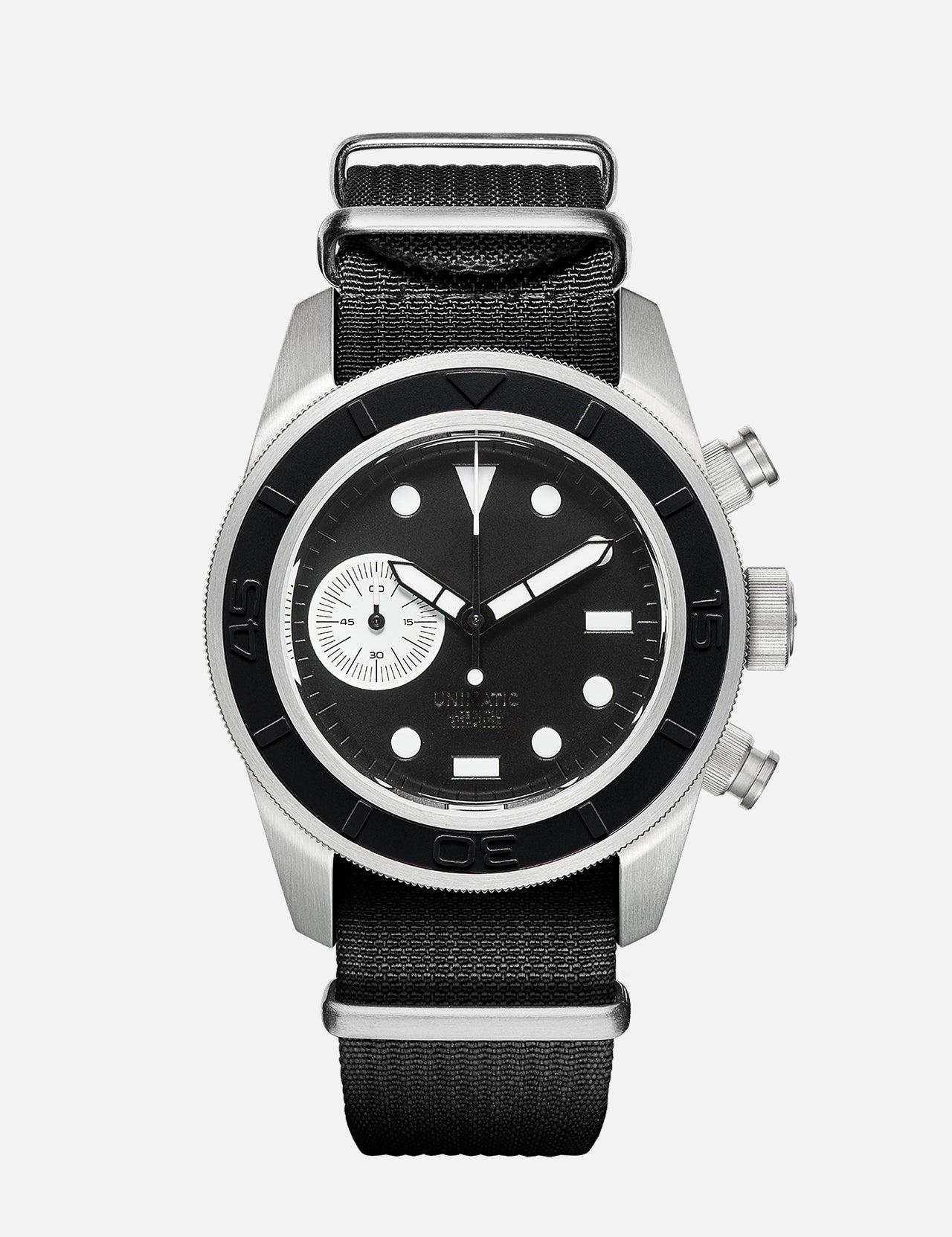 The U3-AE Unimatic Watch by UNIMATIC is an Italian-made timepiece featuring a black and silver round face, white hour markers, a small subdial, two side buttons, and a black fabric strap—showcasing classic design elements inspired by the renowned Unimatic diving watch.