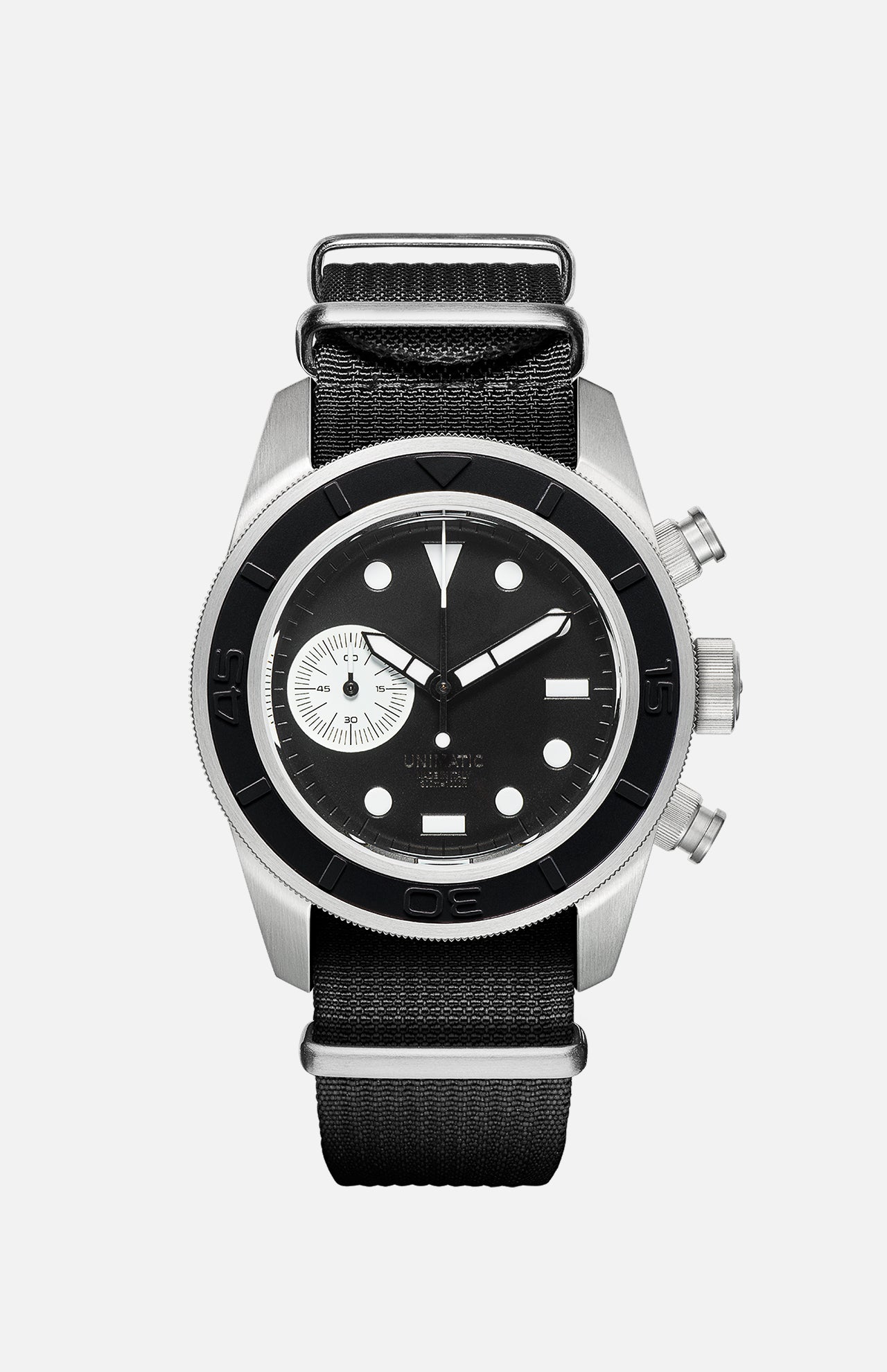 The U3-AE Unimatic Watch by UNIMATIC is an Italian-made timepiece featuring a black and silver round face, white hour markers, a small subdial, two side buttons, and a black fabric strap—showcasing classic design elements inspired by the renowned Unimatic diving watch.