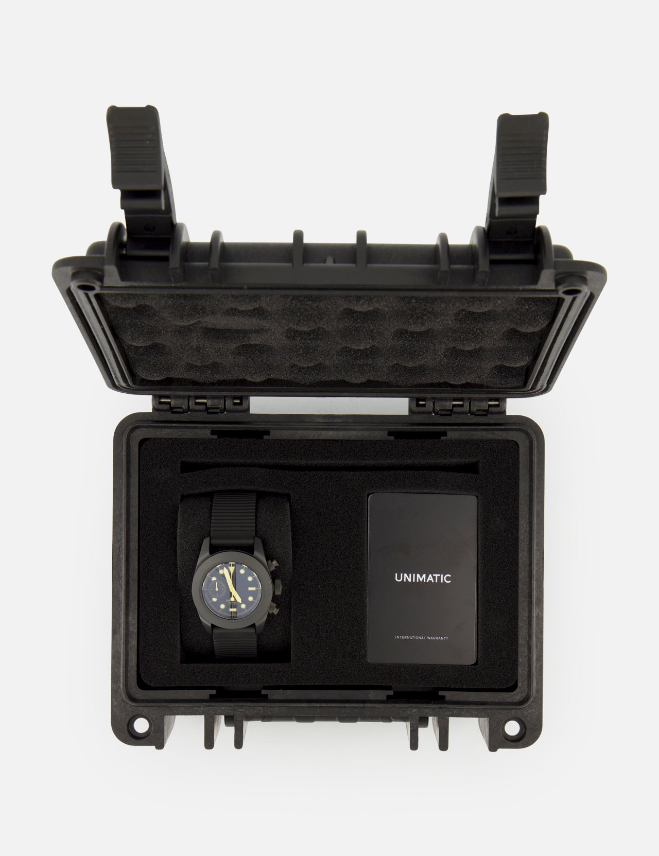 A UNIMATIC Watch Kit U3FB-ROPS, featuring a black Italian diving watch and an instruction manual, is neatly arranged inside an open black protective foam case.