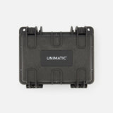 The Unimatic Watch Kit U5S-BL is a black, hard-shell protective case featuring two latches and the UNIMATIC logo in white on a rectangular label on the front. Designed to safeguard your valuable diving watch, the case is shown against a plain white background.