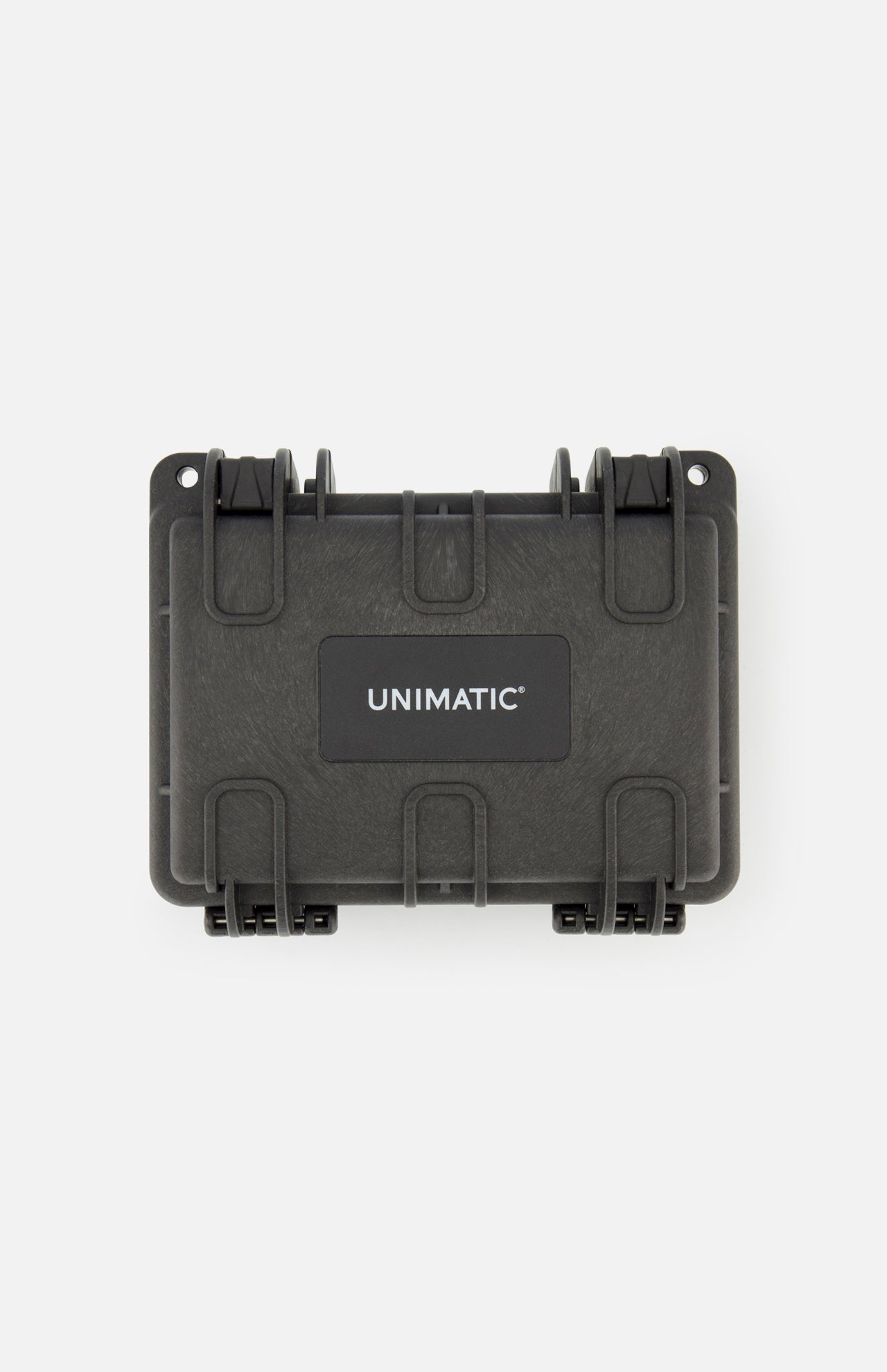The Unimatic Watch Kit U5S-BL is a black, hard-shell protective case featuring two latches and the UNIMATIC logo in white on a rectangular label on the front. Designed to safeguard your valuable diving watch, the case is shown against a plain white background.