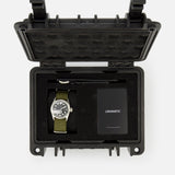 The Unimatic Watch Kit U5S-BL by UNIMATIC includes a diving watch with a green strap, featuring Swiss automatic movement and made in Italy, presented in a black protective case alongside a key and a black UNIMATIC-labeled card, all securely arranged within foam compartments.