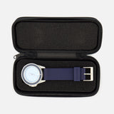 A UNIMATIC UT1-IP Chromatic Trilogy Watch, featuring a blue dial, silver case, and blue strap, is displayed inside an open black zippered case with a foam interior.