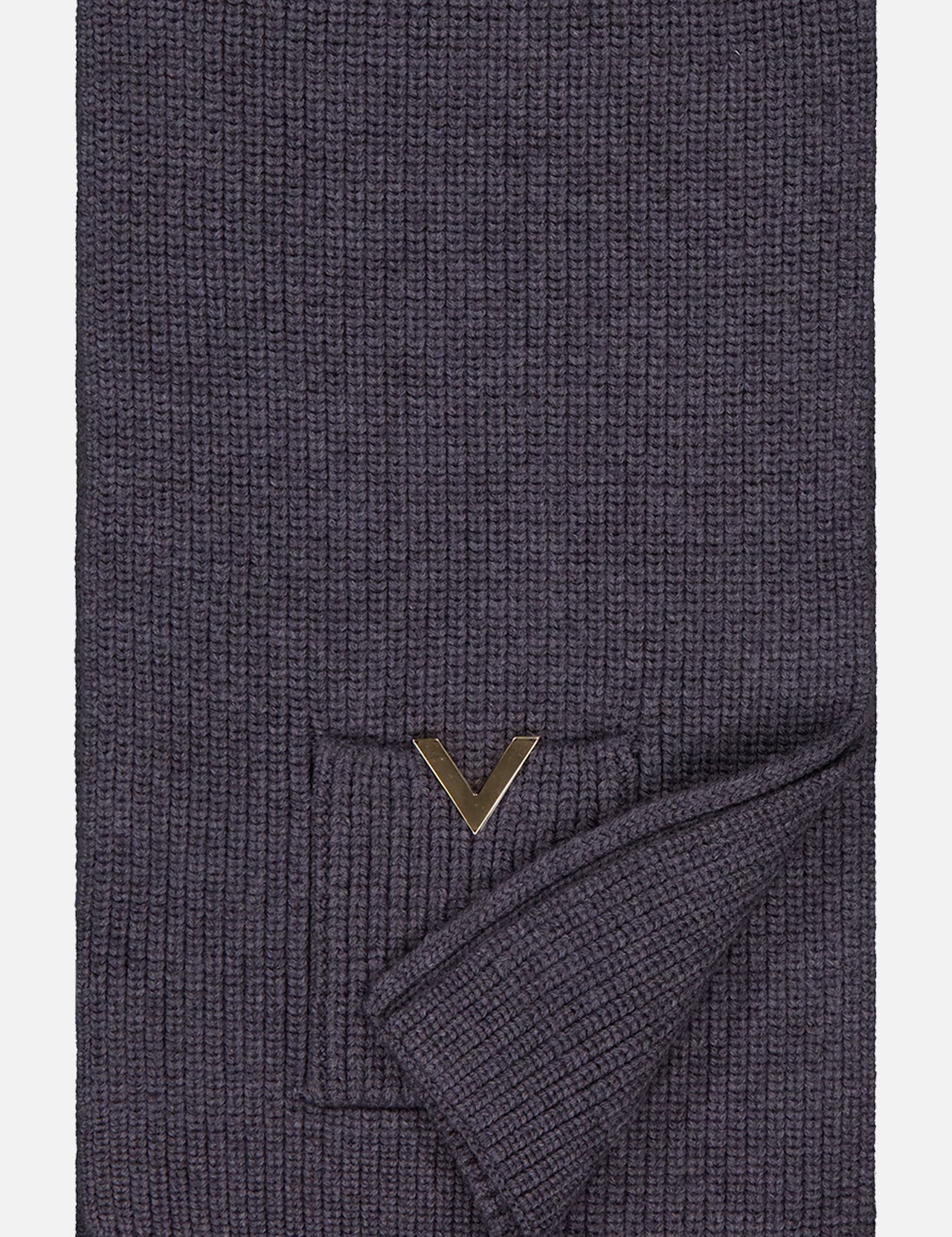 The Knitted Scarf by VALENTINO GARAVANI is a folded, dark gray ribbed virgin wool accessory featuring a small pocket with a gold V-shaped logo detail on one side.