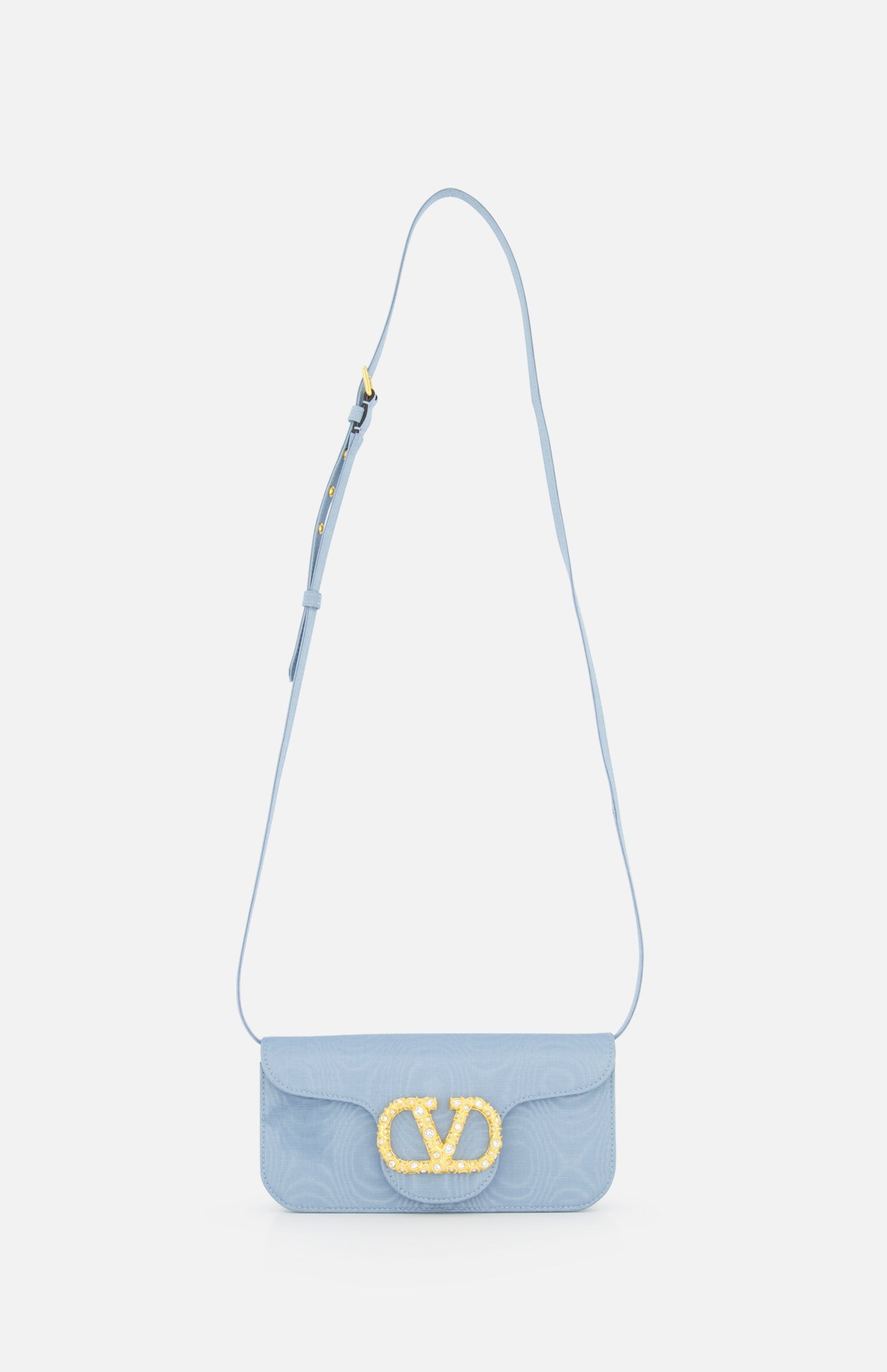 A light blue VALENTINO GARAVANI Loco Swarovski Crystal Clutch with an adjustable strap and a prominent gold VLogo Signature clasp on the front flap, displayed against a plain white background.