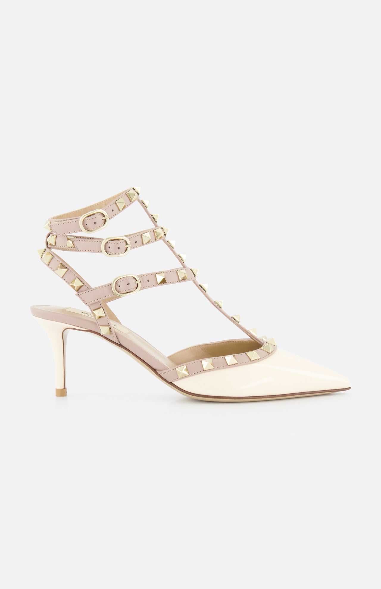The Rockstud Ankle Strap Heel T.65 by VALENTINO GARAVANI is a beige patent leather pump with three nude ankle straps, gold rockstud accents, and a pointed toe, photographed against a plain white background.