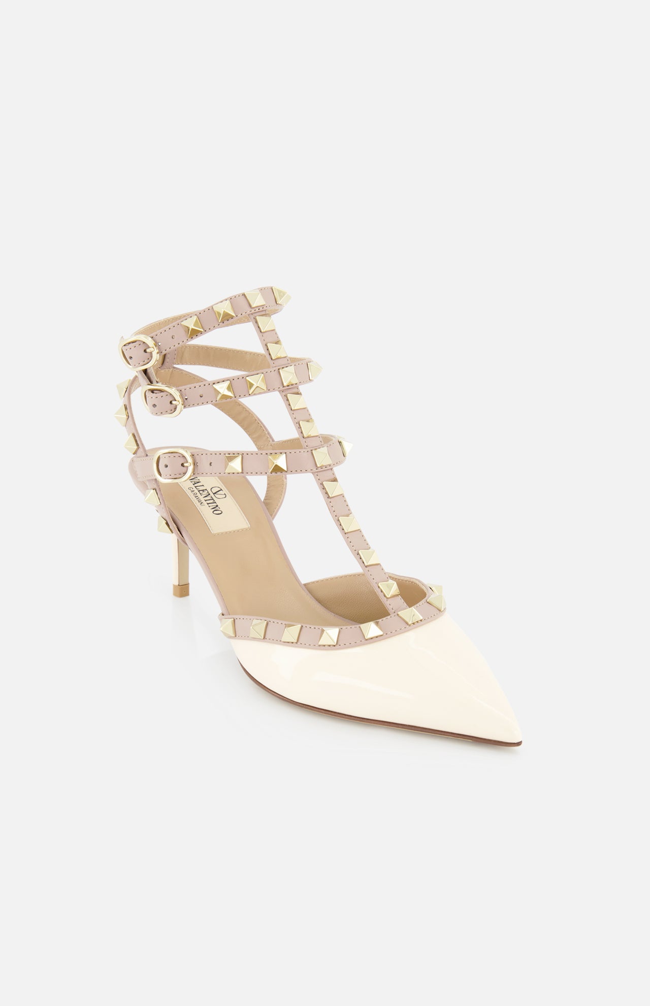 The VALENTINO GARAVANI Rockstud Ankle Strap Heel T.65 is a cream patent leather pump with beige, gold studded straps, three buckle closures, pointed toe, and slim heel for a chic, modern look.