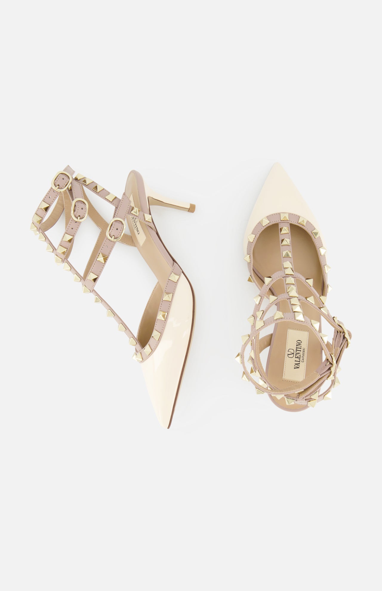 The VALENTINO GARAVANI Rockstud Ankle Strap Heel T.65 features nude patent leather, caged pointed toes, iconic rockstuds, ankle straps with buckle closures, and is shown on a white background.