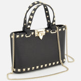 The VALENTINO GARAVANI Rockstud Removable Chain Strap Mini Bag is a black leather purse with gold pyramid studs, a removable gold chain strap, two studded short handles, and a structured rectangular silhouette for edgy elegance.