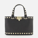 The Valentino Garavani Rockstud Removable Chain Strap Mini Bag is a chic black leather purse with dual handles, gold pyramid studs on the edges and handles, and a gold front clasp, inspired by Valentino’s signature style.