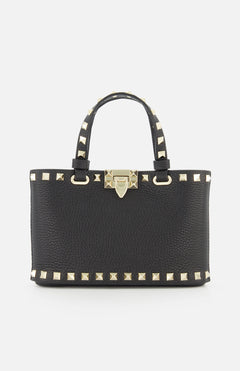 The Valentino Garavani Rockstud Removable Chain Strap Mini Bag is a chic black leather purse with dual handles, gold pyramid studs on the edges and handles, and a gold front clasp, inspired by Valentino’s signature style.