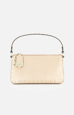 The VALENTINO GARAVANI Rockstud Small Shoulder Bag in beige features gold square studs along the edges, a short handle with stud accents, and a small attached luggage tag, displayed against a plain white background.