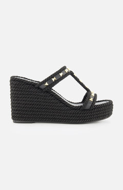 The VALENTINO GARAVANI Rockstud Torchon Slide Espadrillas is a black wedge sandal with braided texture, two gold studded straps, open toe, and a high textured platform heel for stylish lift.