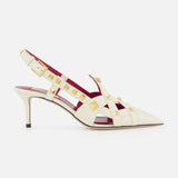 The Valentino Garavani Studdy Sling Back Heel T.65 features ivory leather, pointed toe, gold square studs, strappy ankle strap design, mid-height stiletto heel, and pink-red inner lining against a white background.