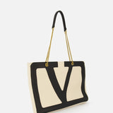 The VALENTINO GARAVANI Viva Superstar Large Tote Bag features cream leather with black V-shaped trim, gold chain and black leather straps—a chic day bag shown against a plain white background.