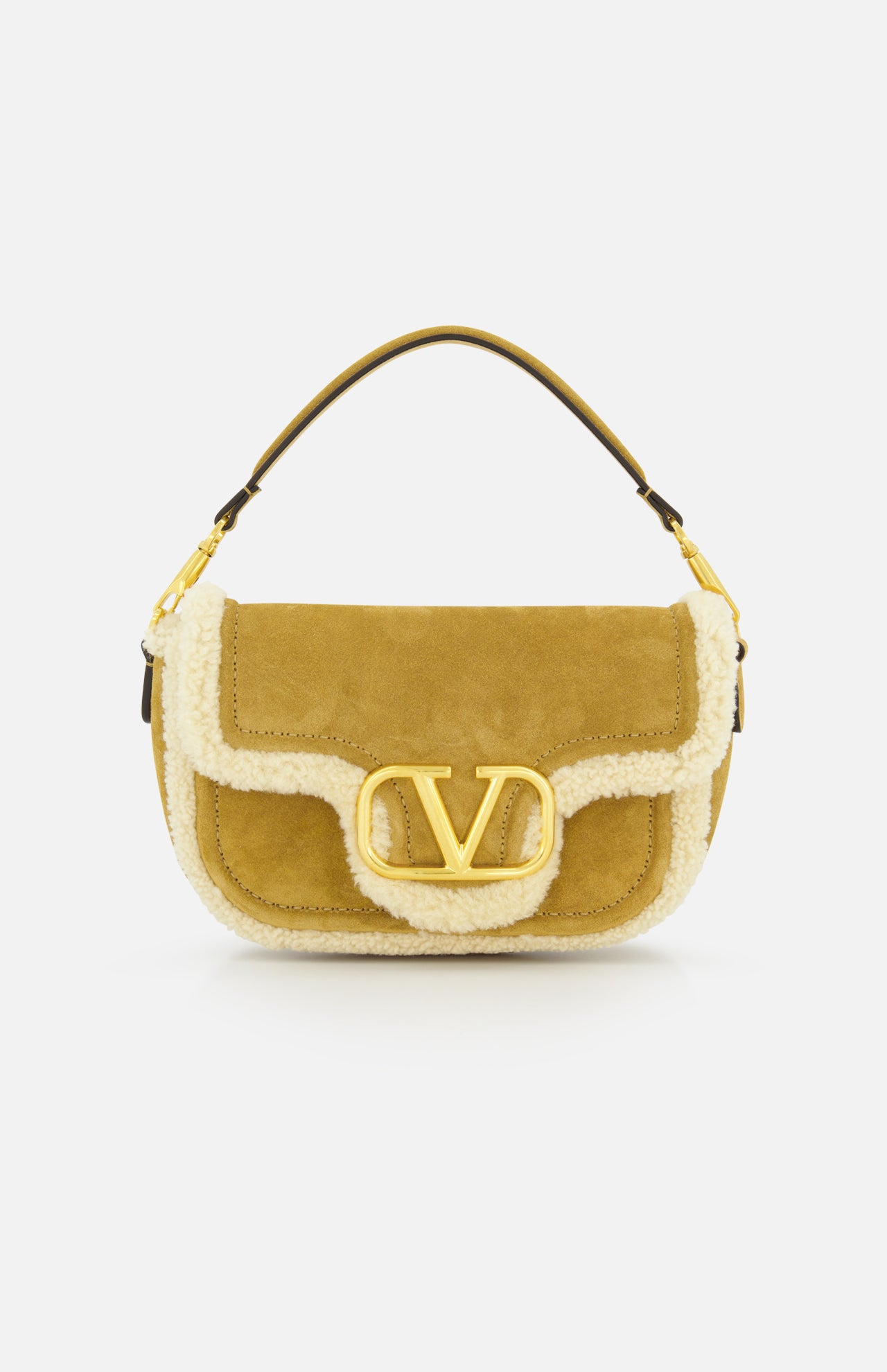 The VALENTINO GARAVANI Alltime Suede Shoulder Bag features tan suede and sheepskin, a cream shearling trim, a short handle, and a large gold VLogo clasp on the flap, shown against a white backdrop.