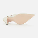 The Cuttie Sling Back Heel by VALENTINO GARAVANI is shown from the bottom, displaying its pointed toe, pale beige sole, white upper, and thin stiletto heel, with the ivory leather slingback positioned toe-up on a white background.