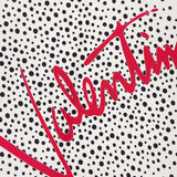 A white background with black polka dots and "VALENTINO GARAVANI" diagonally in bold red creates a striking Foulards Polka Dot Shawl—an elegant silk accessory made in Italy.