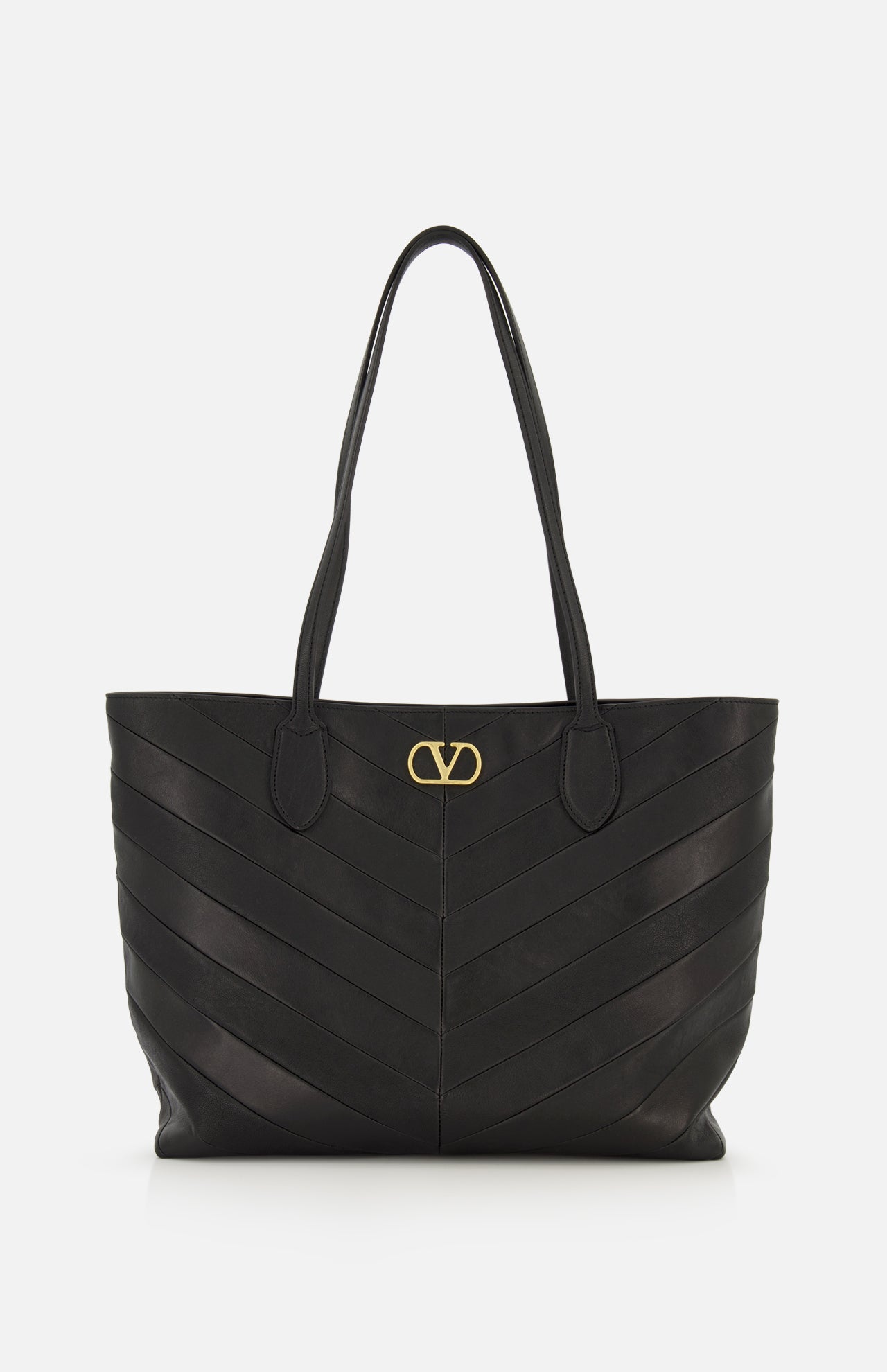 Valentino Garavani Jean Medium Tote Bag in black leather with a chevron-stitched pattern and a gold metal logo emblem at the top center.