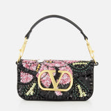 The Loco Small Shoulder Bag by VALENTINO GARAVANI is a black evening bag adorned with a vibrant floral sequin design in pink, green, and yellow. Featuring a gold Valentino logo clasp and a sleek black handle with gold hardware, this sparkling sequined minaudière effortlessly elevates any look.