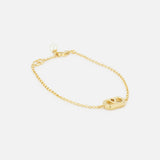 The VALENTINO GARAVANI Ovalette Pearl Bracelet features a delicate gold-tone chain, an oval cut-out charm with logo detailing, and a round Swarovski pearl accent by the clasp, shown on a white background.