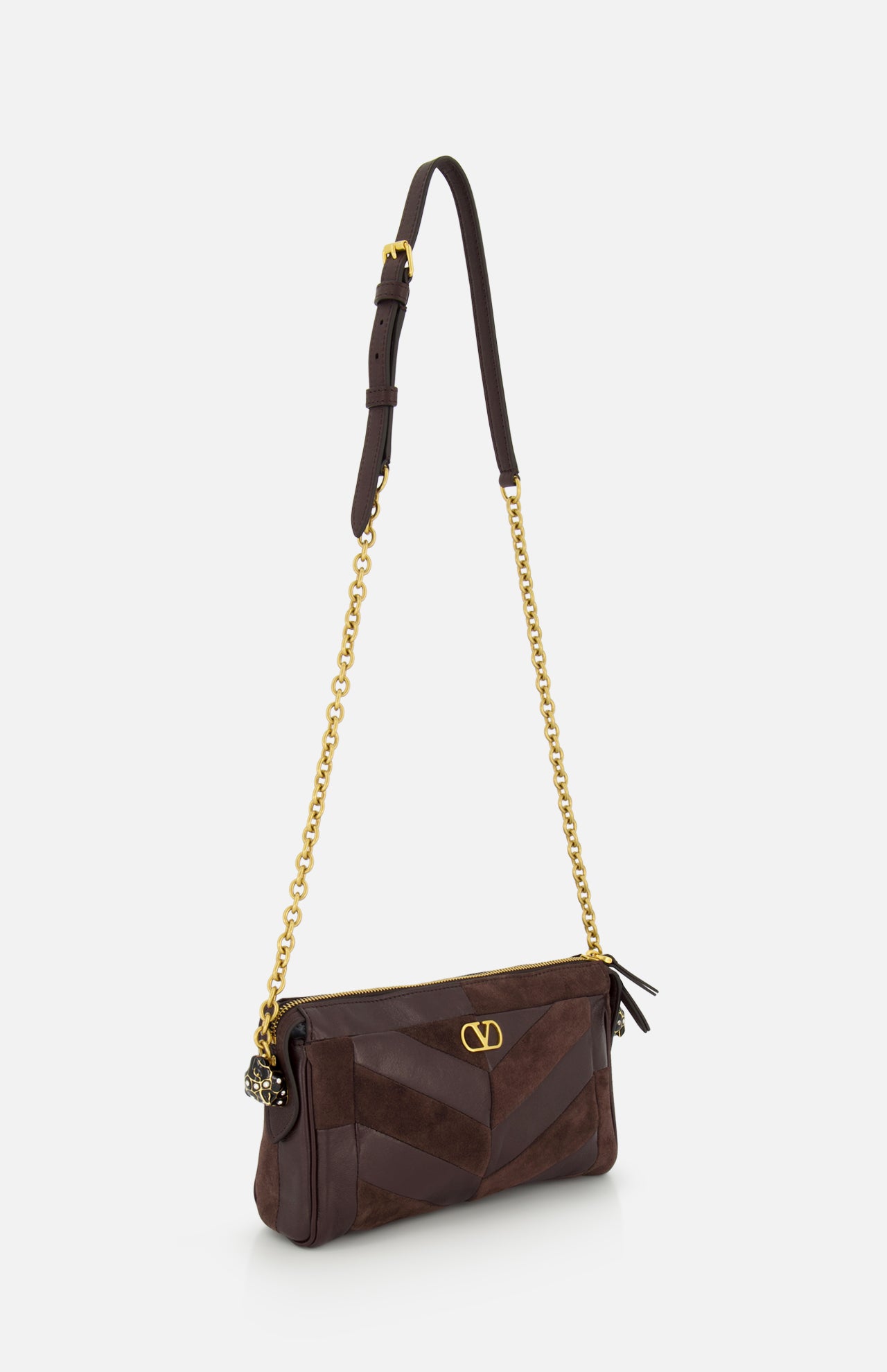 Introducing the Panthea Small Patchwork Shoulder Bag by VALENTINO GARAVANI—a sophisticated dark brown shoulder bag expertly crafted from a luxurious mix of suede and leather. This elegant accessory features a striking geometric patchwork pattern on the front, complemented by gold-tone hardware, a distinctive V logo emblem, and a chic gold chain strap. Finished with a secure zipper closure, this bag effortlessly blends modern style with timeless refinement.