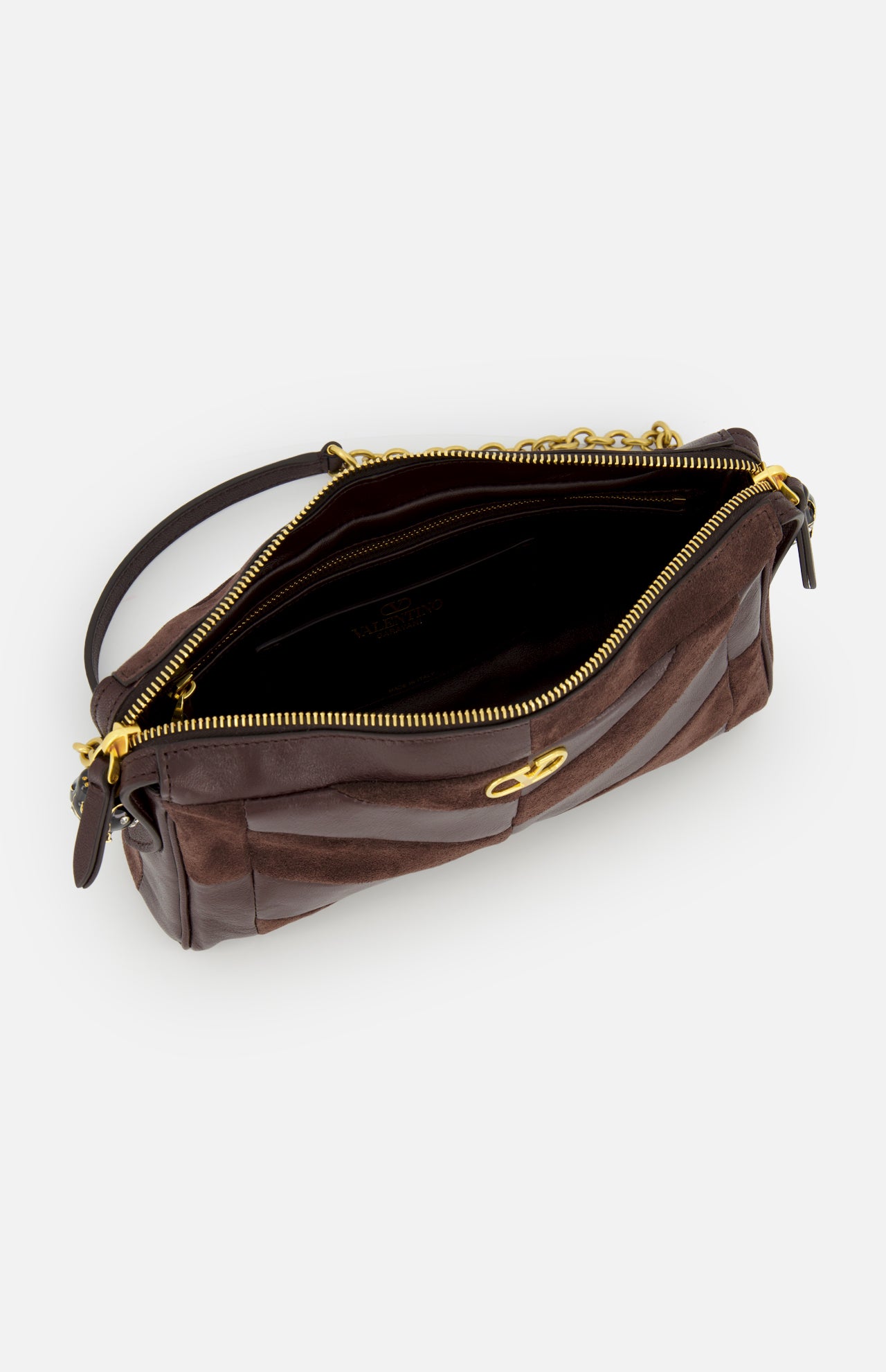The Panthea Small Patchwork Shoulder Bag by VALENTINO GARAVANI is a dark brown shoulder bag crafted from luxurious suede and leather, featuring a gold zipper, gold clasp detail, and a short handle. Shown from above with the bag open to reveal the interior, this handbag combines timeless elegance with modern sophistication.