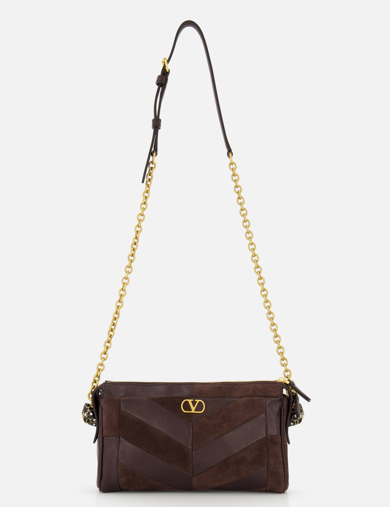Introducing the Panthea Small Patchwork Shoulder Bag by VALENTINO GARAVANI—a luxurious handbag crafted from dark brown suede and leather. This sophisticated accessory is adorned with a gold chain strap, elegant gold hardware, and a signature small gold “V” emblem on the front. Subtle Swarovski crystal accents provide the perfect touch of sparkle to its refined design.