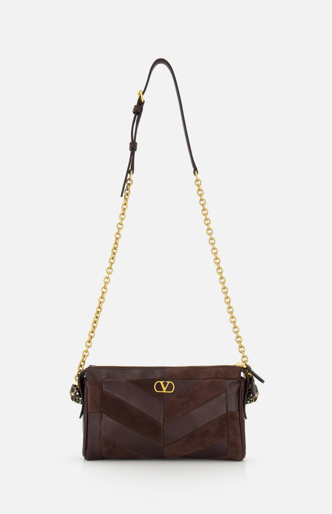 Introducing the Panthea Small Patchwork Shoulder Bag by VALENTINO GARAVANI—a luxurious handbag crafted from dark brown suede and leather. This sophisticated accessory is adorned with a gold chain strap, elegant gold hardware, and a signature small gold “V” emblem on the front. Subtle Swarovski crystal accents provide the perfect touch of sparkle to its refined design.