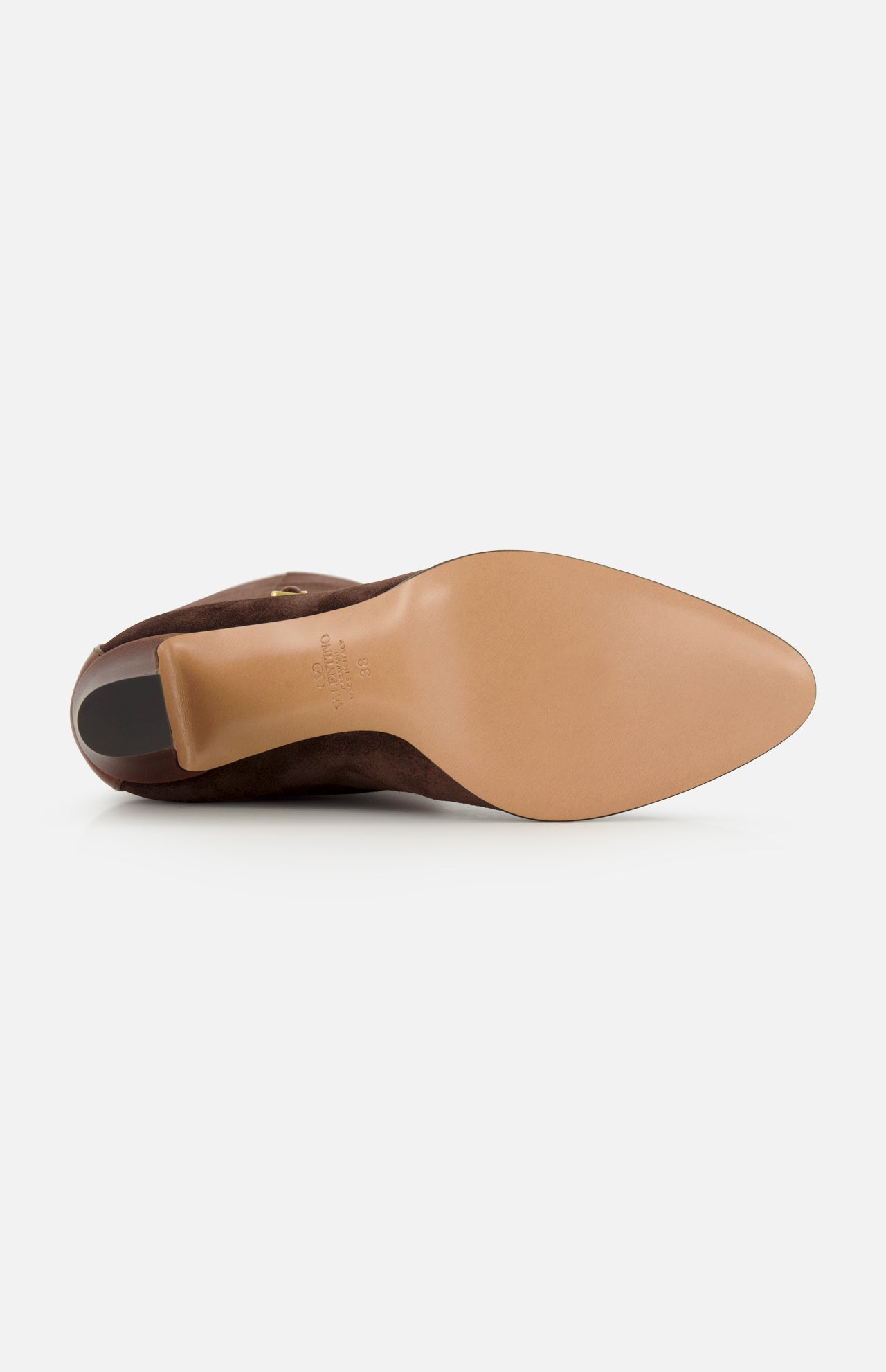 The VALENTINO GARAVANI Pattie Suede Ankle Strap Boot is pictured from the bottom, showcasing its smooth tan sole and pointed toe against a white background, echoing the refined elegance of tall suede boots.