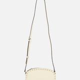 The VALENTINO GARAVANI Rockstud Camera Case Bag is a cream oval handbag with gold-tone studs along the edges and an adjustable long strap, shown against a plain white background.